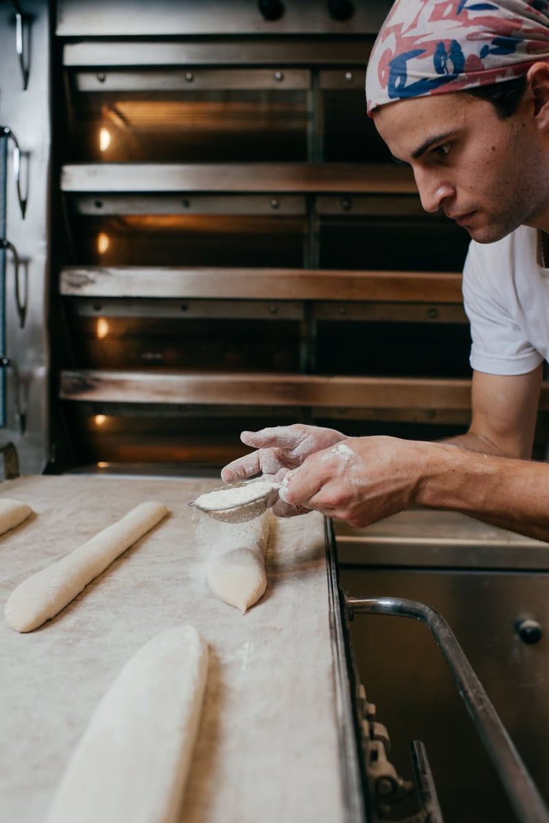 Graison Gill dusting baguette dough before baking.